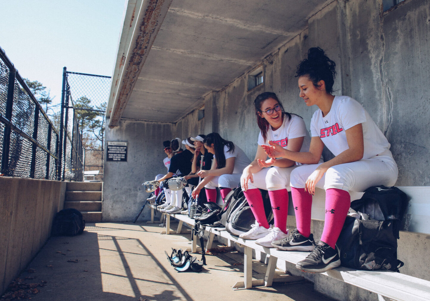 Team Steel softball players in the dugout